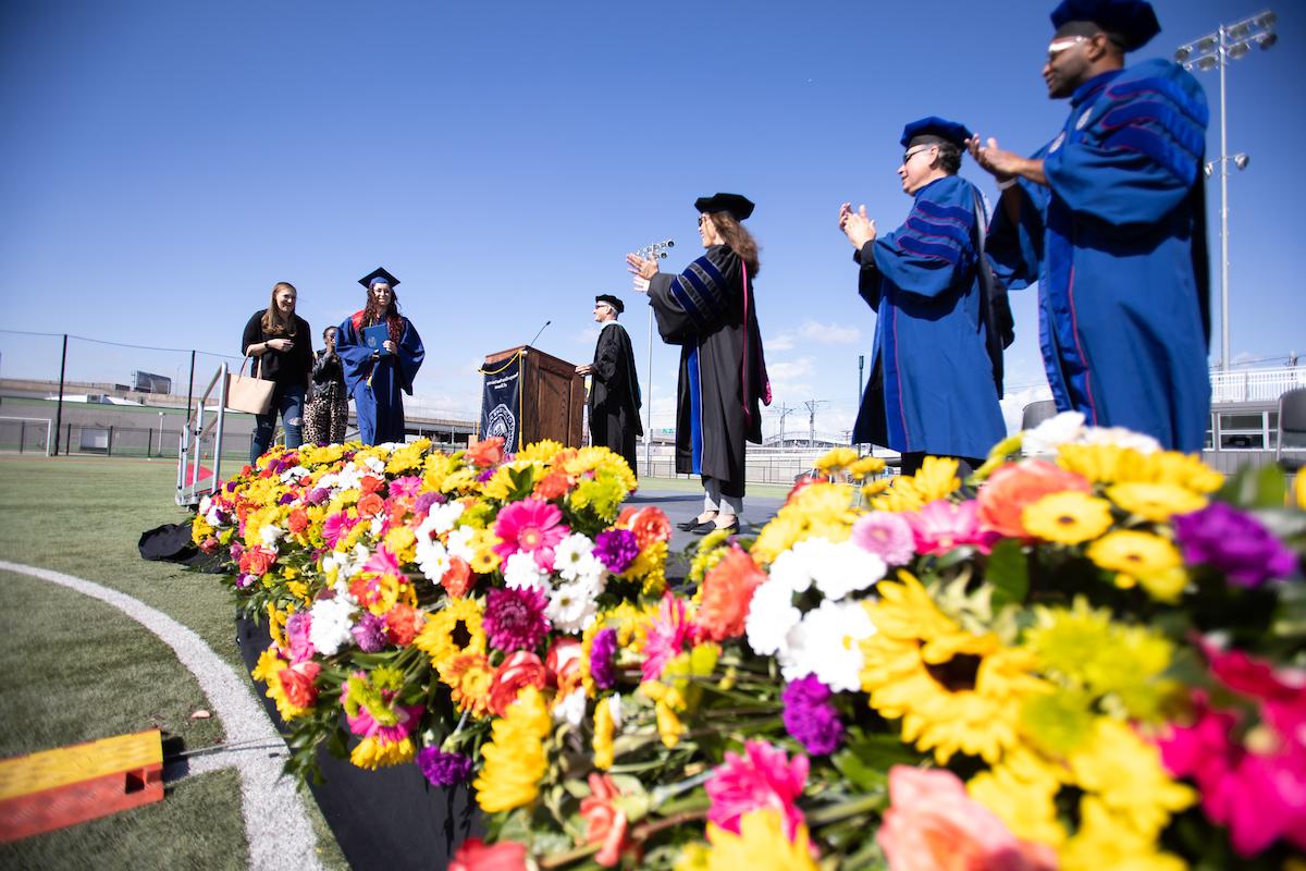 密歇根州立大学丹佛 student walking across the stage at Spring 2021 Commencement